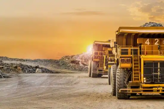 Large yellow dump trucks transporting ore for processing.