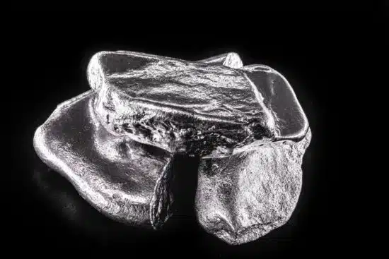 Silver pieces of rhodium on a black background.