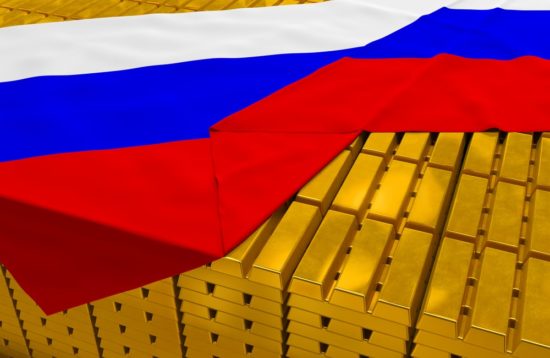 A pile of gold barscovered by a Russian flag.