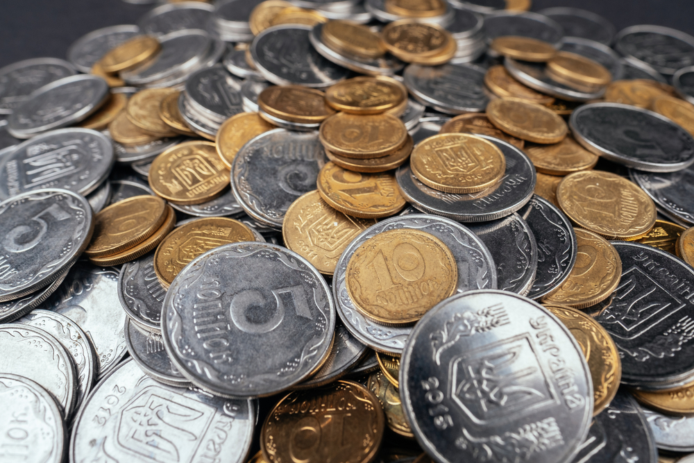 Stacks of gold and silver-colored coins representing market volatility as investors watch gold prices next week ahead of the U.S. Jobs Report.
