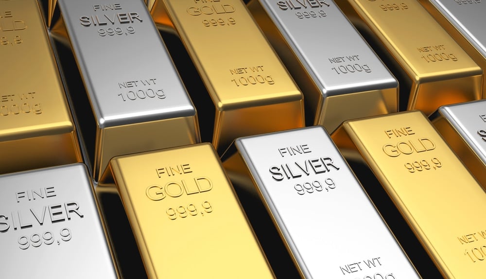 Gold and silver bullion bars labeled fine gold stacked side by side