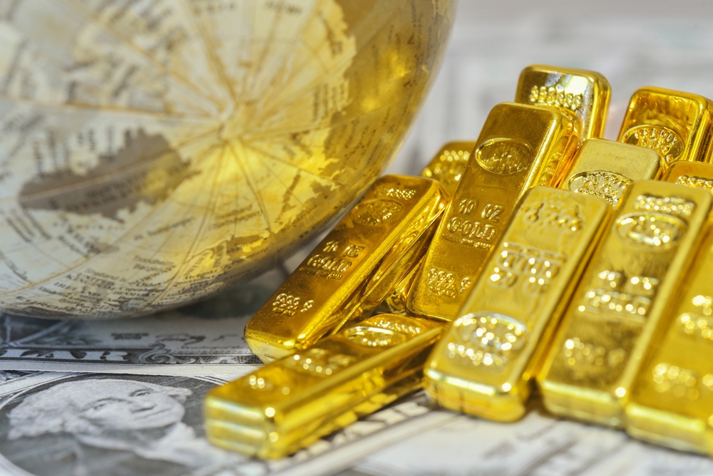 Gold bars stacked on U.S. dollar bills beside a globe illustrating the Gold Market Weekly Recap and the global forces driving precious metals higher.