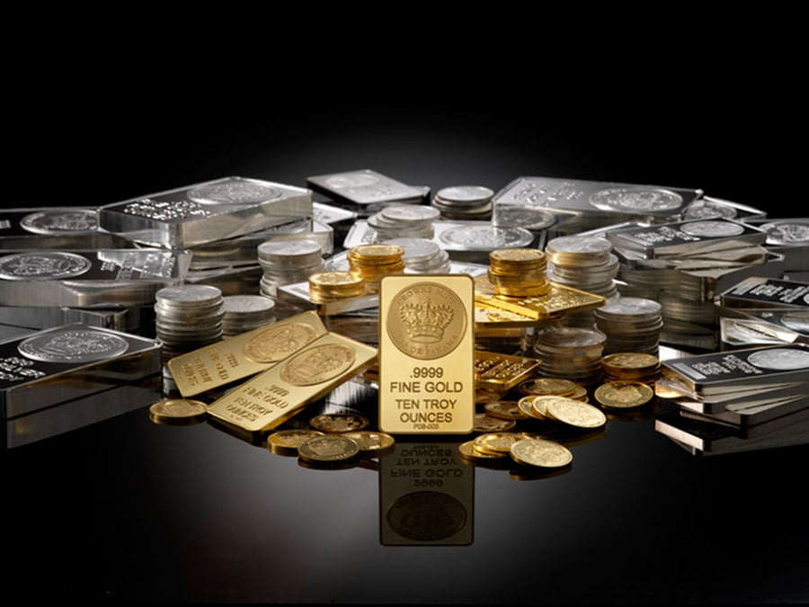 Gold and silver bars and coins including a 10 troy oz fine gold bullion bar surrounded by silver ingots