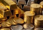 Gold and silver bars stacked beside mixed coins on wooden surface, representing precious metals market volatility