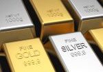 Gold and silver bullion bars labeled fine gold stacked side by side
