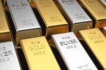 Gold and silver bullion bars labeled fine gold stacked side by side