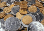 Stacks of gold and silver-colored coins representing market volatility as investors watch gold prices next week ahead of the U.S. Jobs Report.