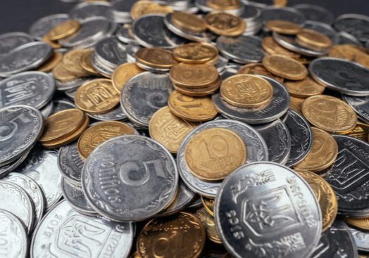 Stacks of gold and silver-colored coins representing market volatility as investors watch gold prices next week ahead of the U.S. Jobs Report.